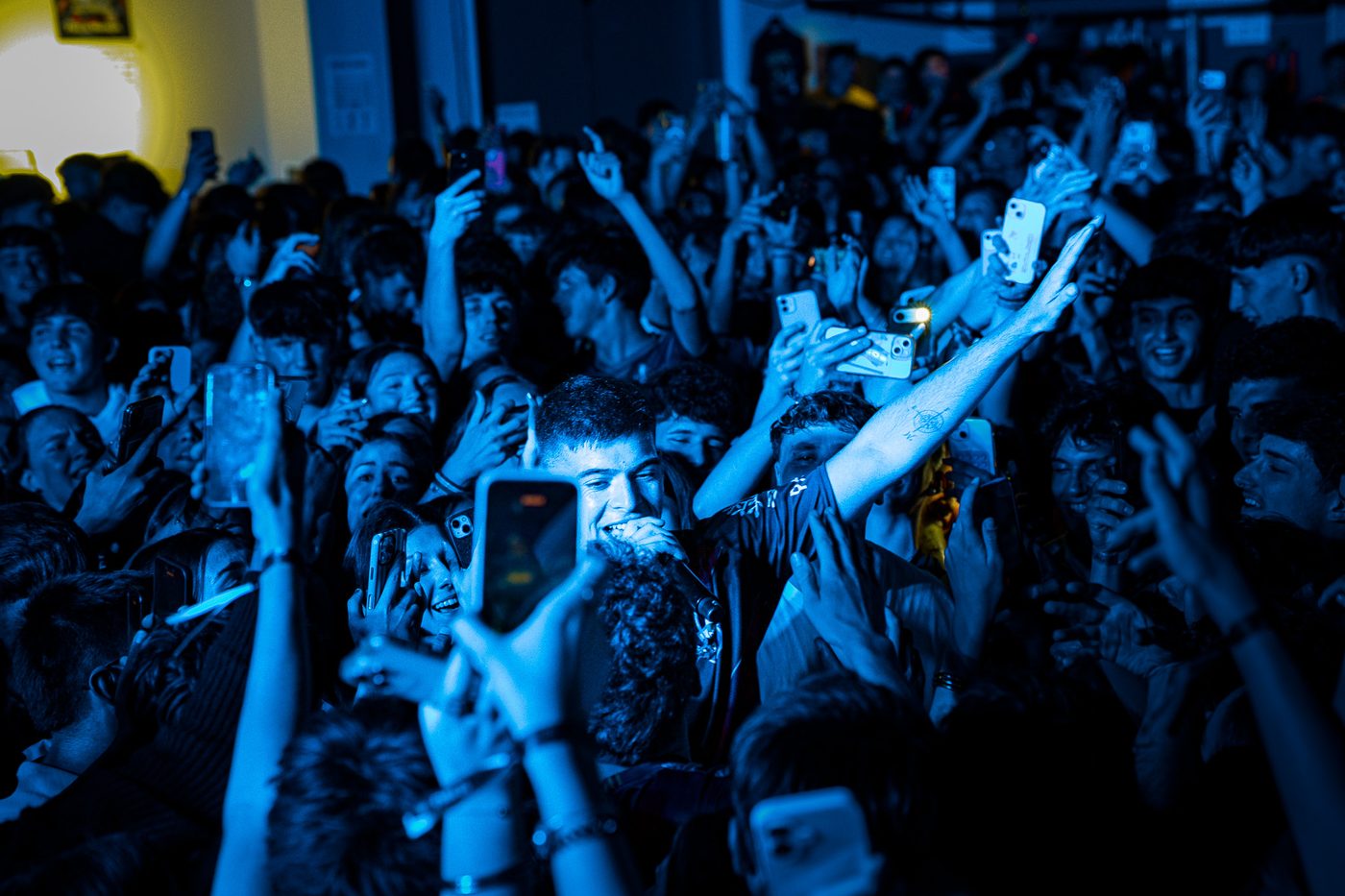 Fotografía de concierto — artista en medio del público luz azul
